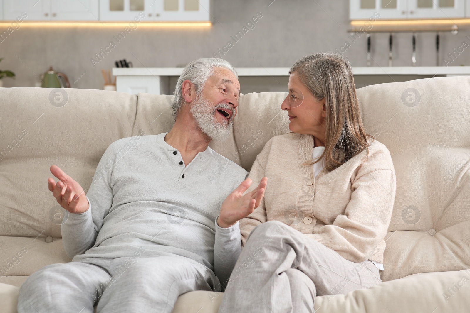 Photo of Affectionate senior couple relaxing on sofa at home