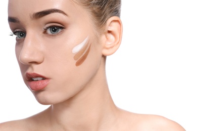 Photo of Young woman with different shades of skin foundation on her face against white background. Professional makeup