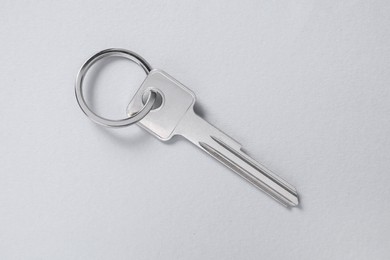 Photo of One key with ring on light background, top view