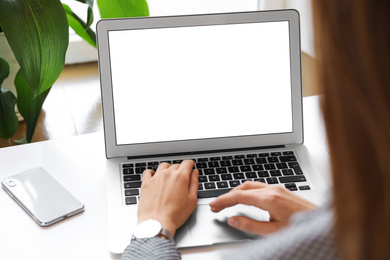 Young woman using modern computer at table in office, closeup. Space for design