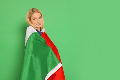 Woman with flag of Italy on green background, space for text