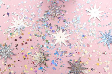 Photo of Shiny glitter on light pink background, flat lay