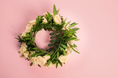 Wreath made of beautiful flowers on pink background, top view