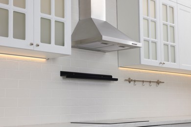 Photo of Modern range hood and furniture in kitchen