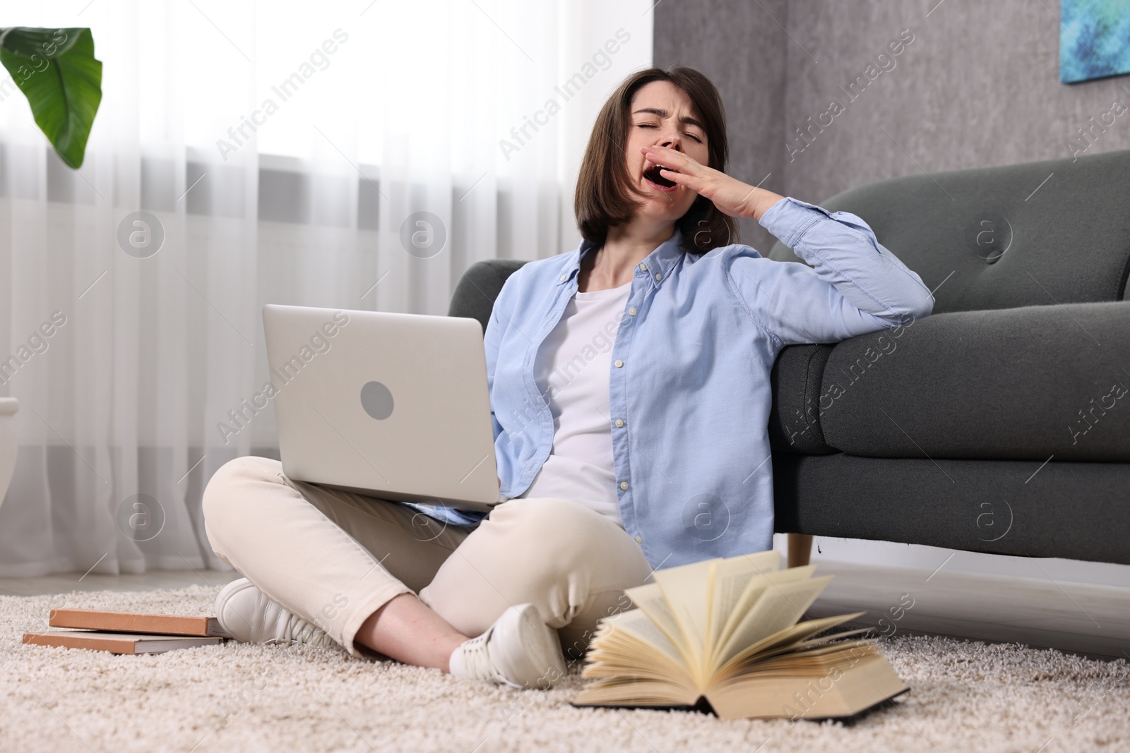 Photo of Overwhelmed woman with laptop sitting on floor indoors