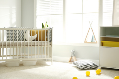 Photo of Cute baby room interior with crib and big window