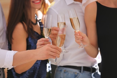 Friends clinking glasses with champagne at party, closeup