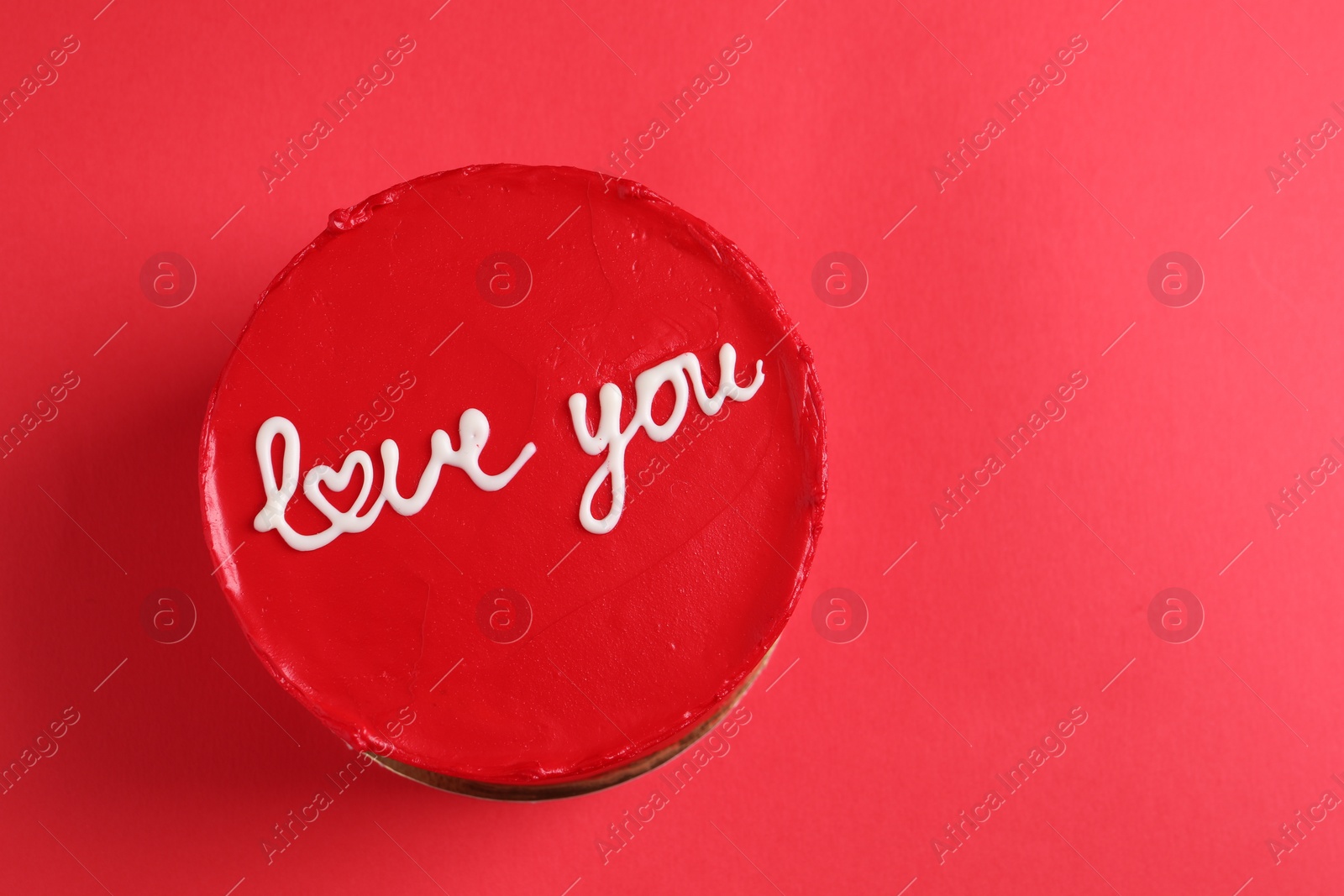 Photo of Bento cake with text Love You and space for text on red table, top view. St. Valentine's day surprise