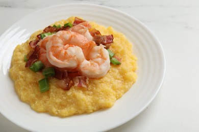 Photo of Plate with fresh tasty shrimps, bacon, grits and green onion on white table, closeup