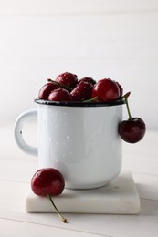 Photo of Fresh ripe cherries with water drops on white wooden table