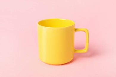 One yellow ceramic mug on pink background