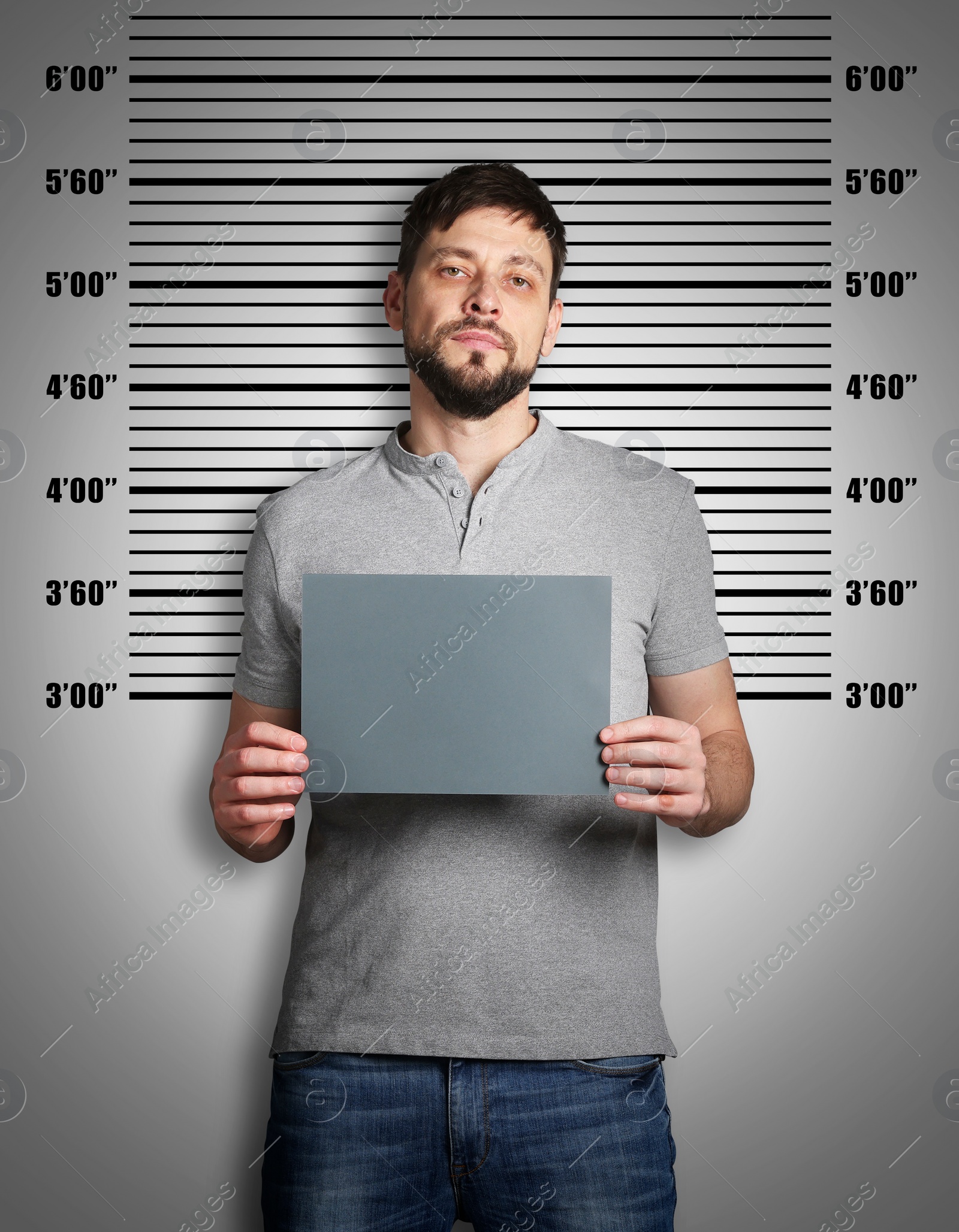 Image of Criminal mugshot. Arrested man with blank card against height chart