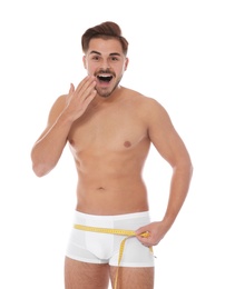 Photo of Fit man measuring his hips on white background. Weight loss