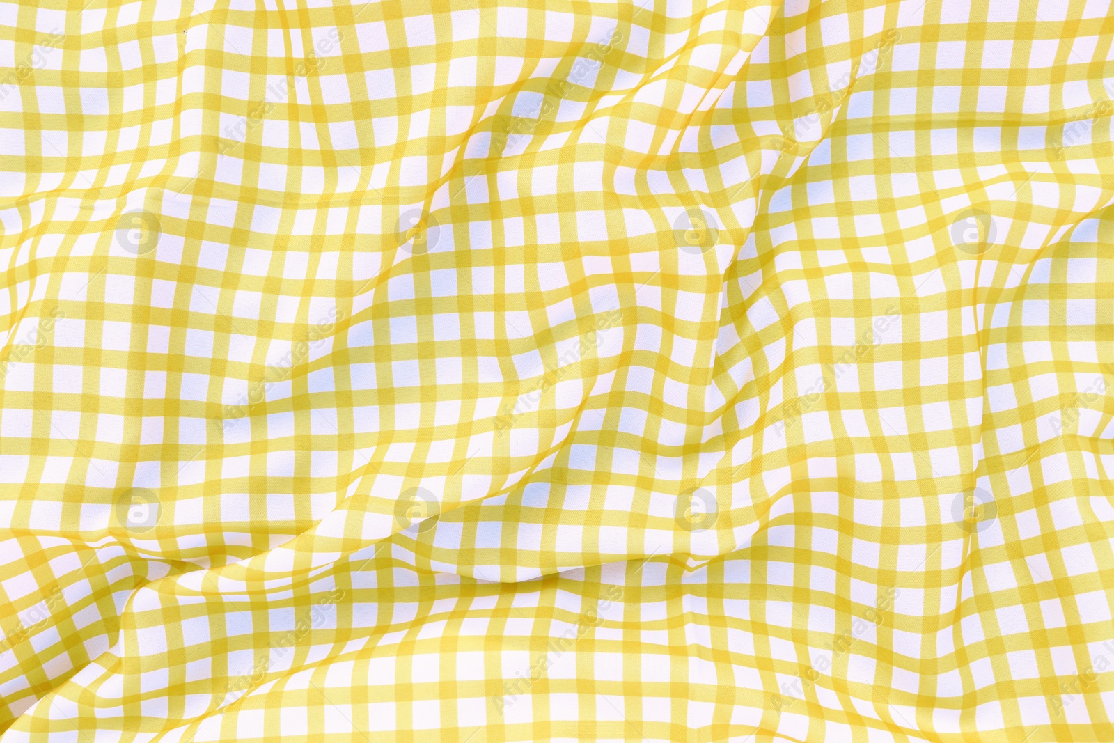 Photo of Yellow checkered picnic tablecloth as background, top view