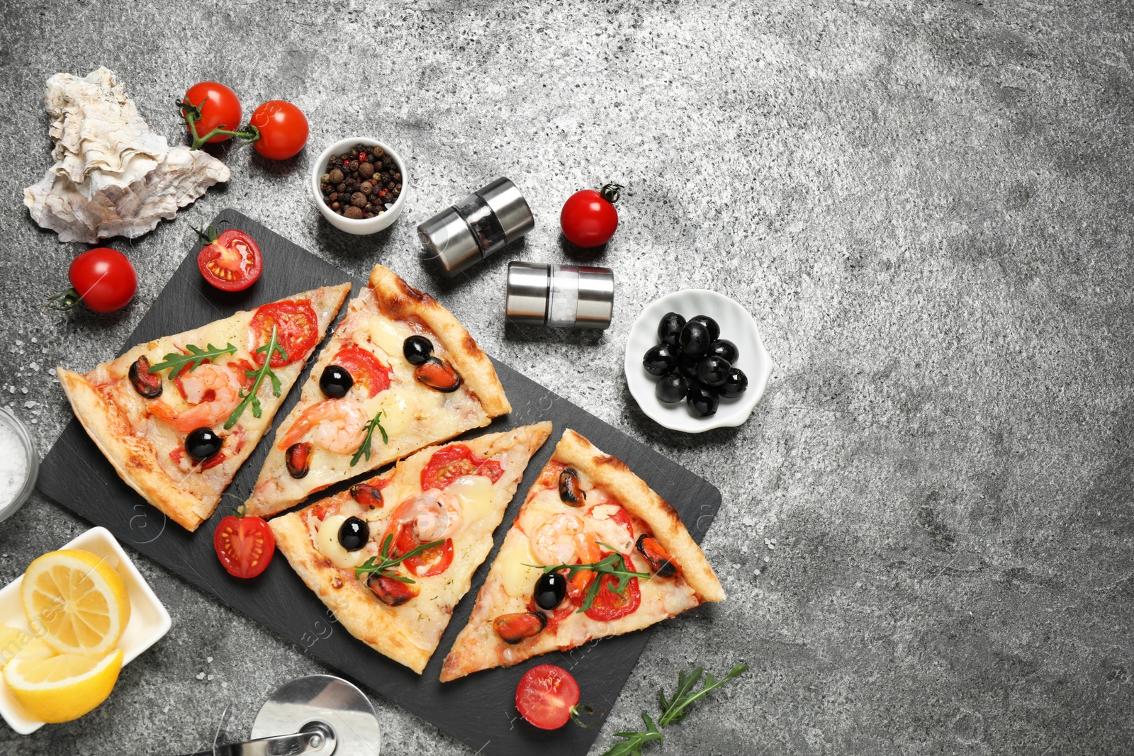 Photo of Tasty pizza with seafood and ingredients on grey table, flat lay. Space for text