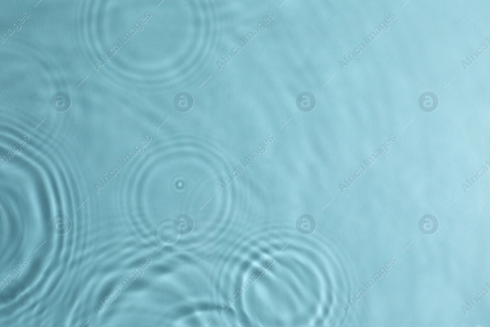 Photo of Closeup view of water with circles on turquoise background. Space for text