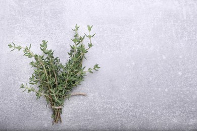 Photo of Bunch of fresh thyme on light grey table, top view. Space for text