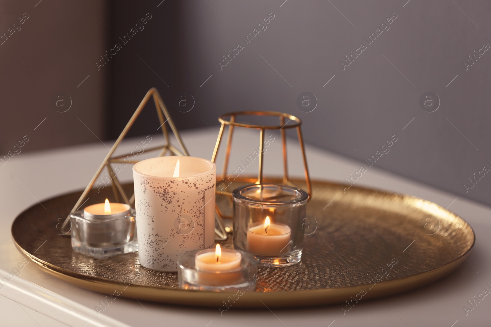Photo of Beautiful burning candles and decor on table at home