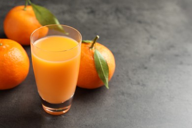 Delicious tangerine liqueur and fresh fruits on grey table, closeup. Space for text