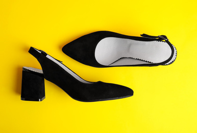 Stylish female shoes on yellow background, flat lay