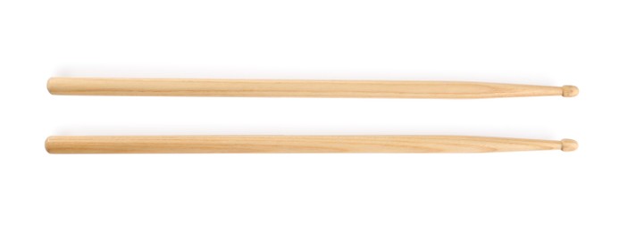 Photo of Two wooden drumsticks on white background, top view