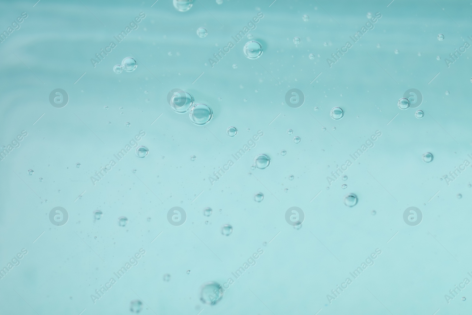 Photo of Pure transparent cosmetic gel on light blue background, closeup