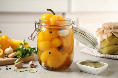 Photo of Glass jar with pickled peppers on grey table