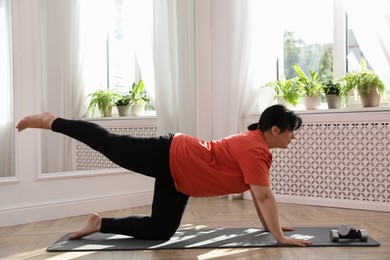 Overweight mature woman doing exercise at home