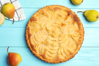 Photo of Delicious sweet tart with pears on light blue wooden table, flat lay