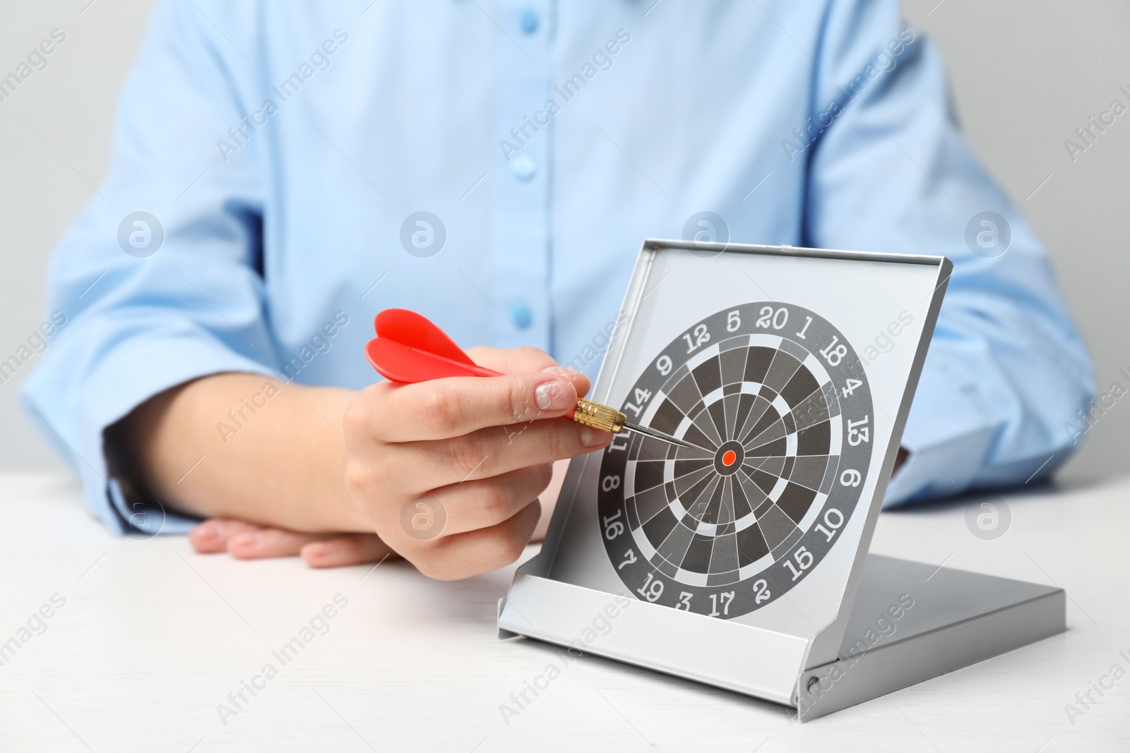 Photo of Woman with darts at table. Business trainer concept