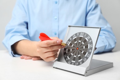 Photo of Woman with darts at table. Business trainer concept