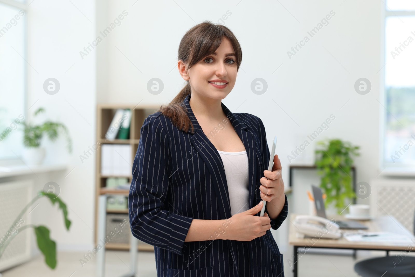 Photo of Portrait of smiling secretary with tablet in office