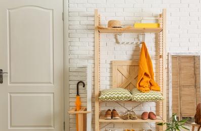 Photo of Cozy hallway interior with wooden shelving unit. Stylish design idea