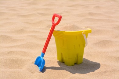 Photo of Plastic bucket and shovel on sand. Beach toys