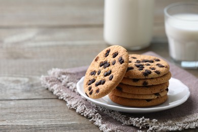 Photo of Delicious chocolate chip cookies on wooden table, space for text