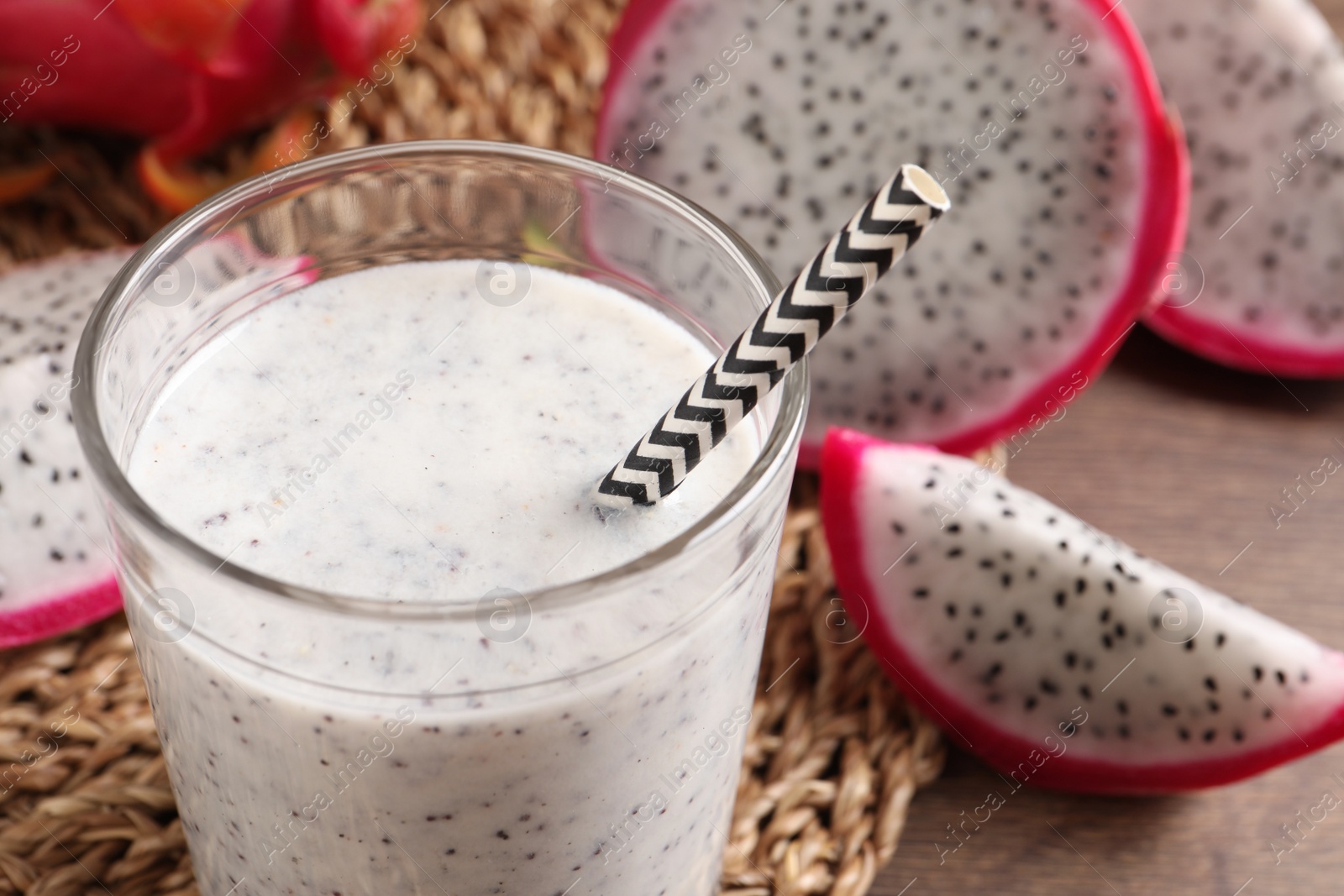 Photo of Delicious pitahaya smoothie and fresh fruits on table, closeup