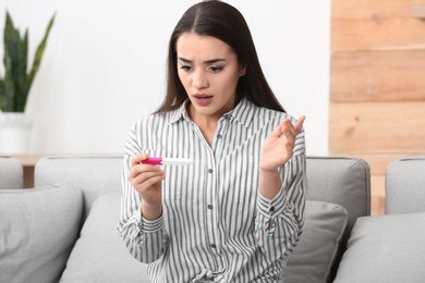 Young woman with pregnancy test at home. Gynecology and childbirth