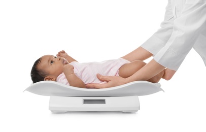 Photo of Doctor weighting African-American baby on scales against white background