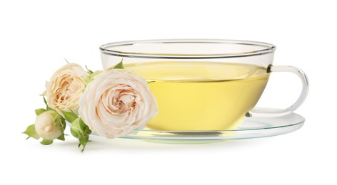 Aromatic herbal tea in glass cup and roses isolated on white