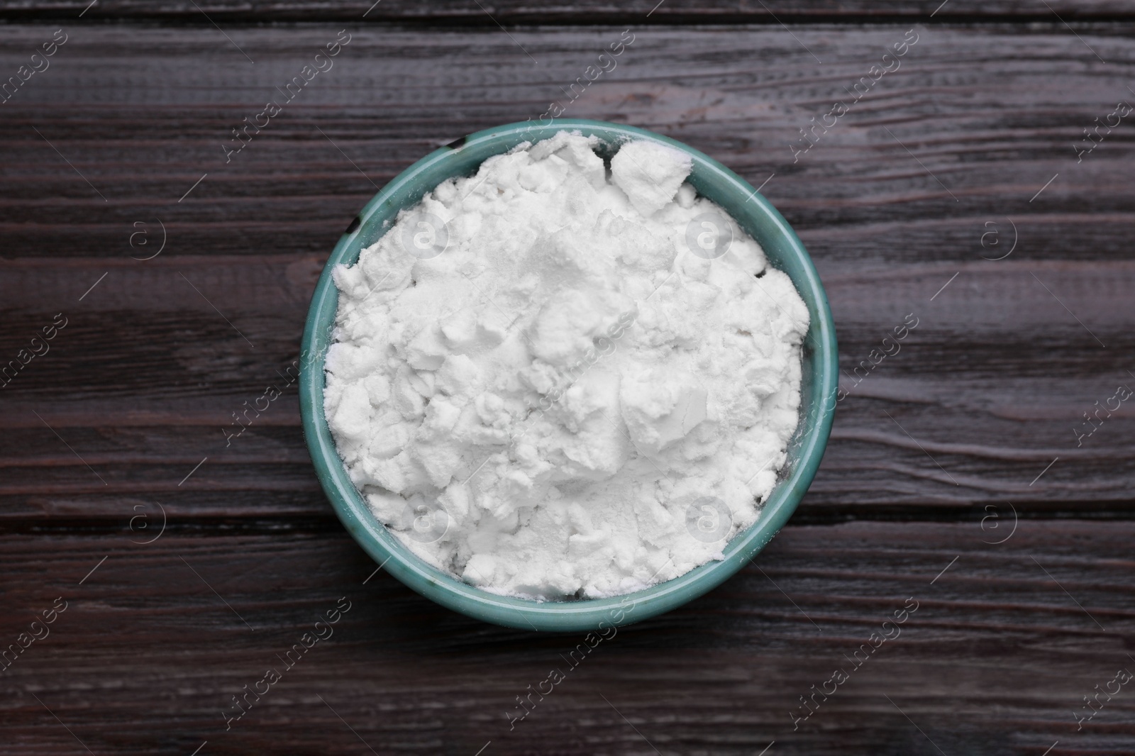 Photo of Starch in bowl on wooden table, top view