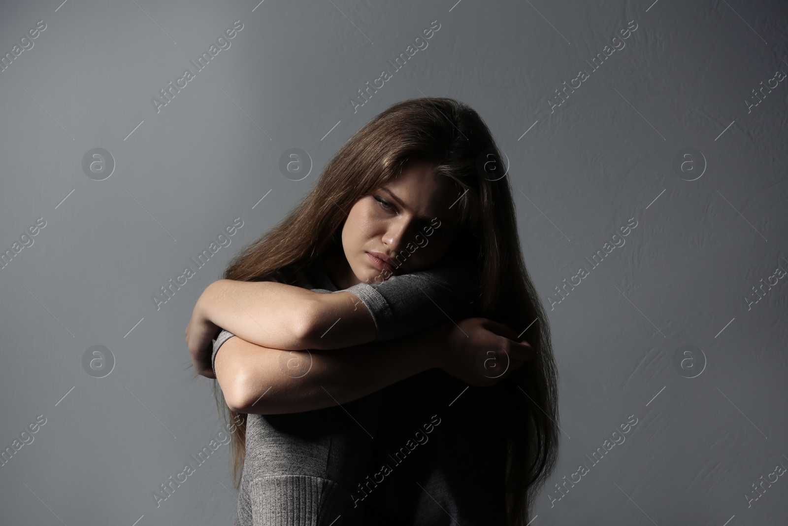 Photo of Depressed young woman on gray background