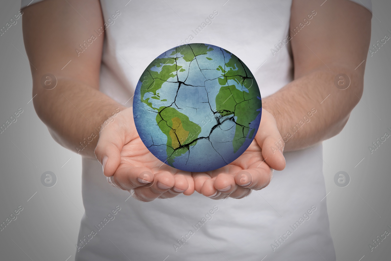 Image of Man holding Earth with medical mask on light background, closeup. Concept of coronavirus outbreak