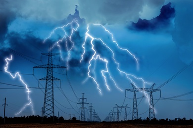 Picturesque lightning storm over field with high voltage towers