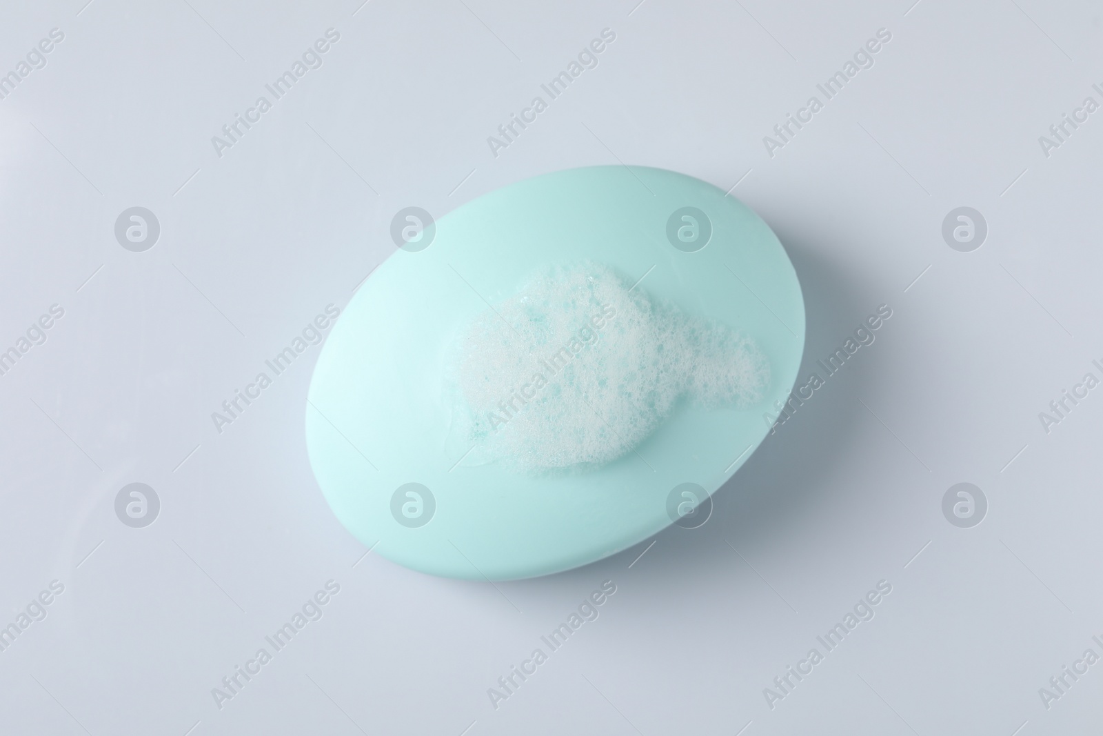 Photo of Soap with fluffy foam on white background, top view