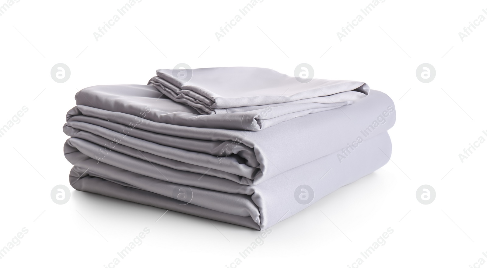 Photo of Stack of clean silky bed linen isolated on white