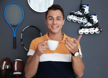 Photo of Portrait of sport blogger with cup of coffee at home