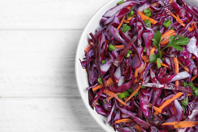 Photo of Fresh red cabbage salad on white wooden table