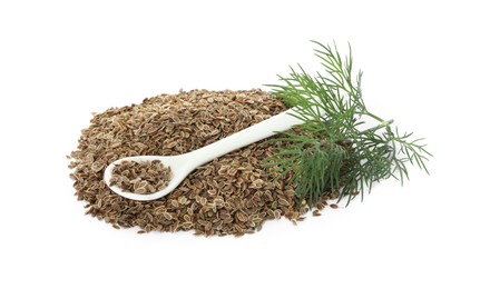 Pile of dry seeds, fresh dill and spoon isolated on white