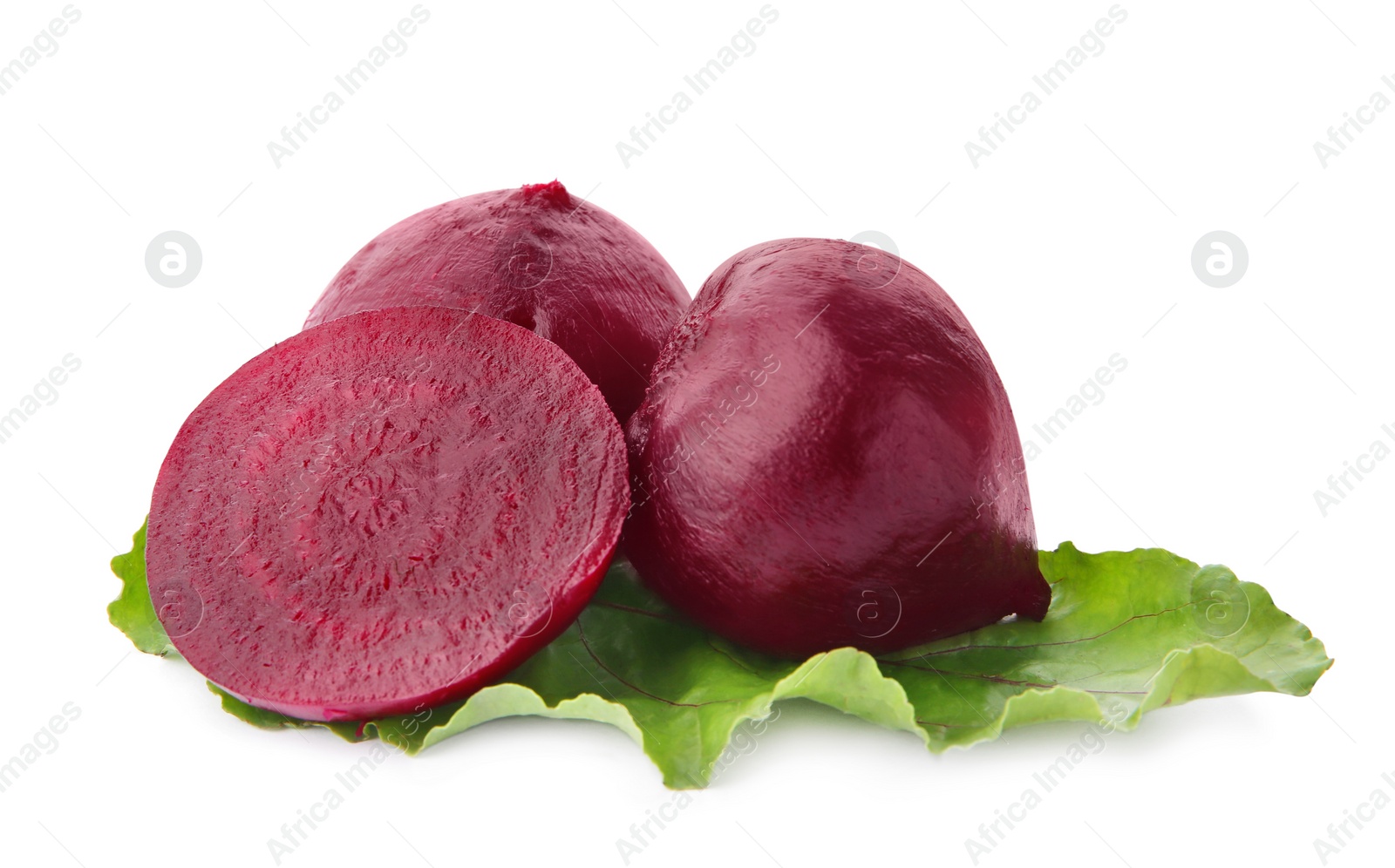 Photo of Whole and cut boiled red beets with green leaf on white background