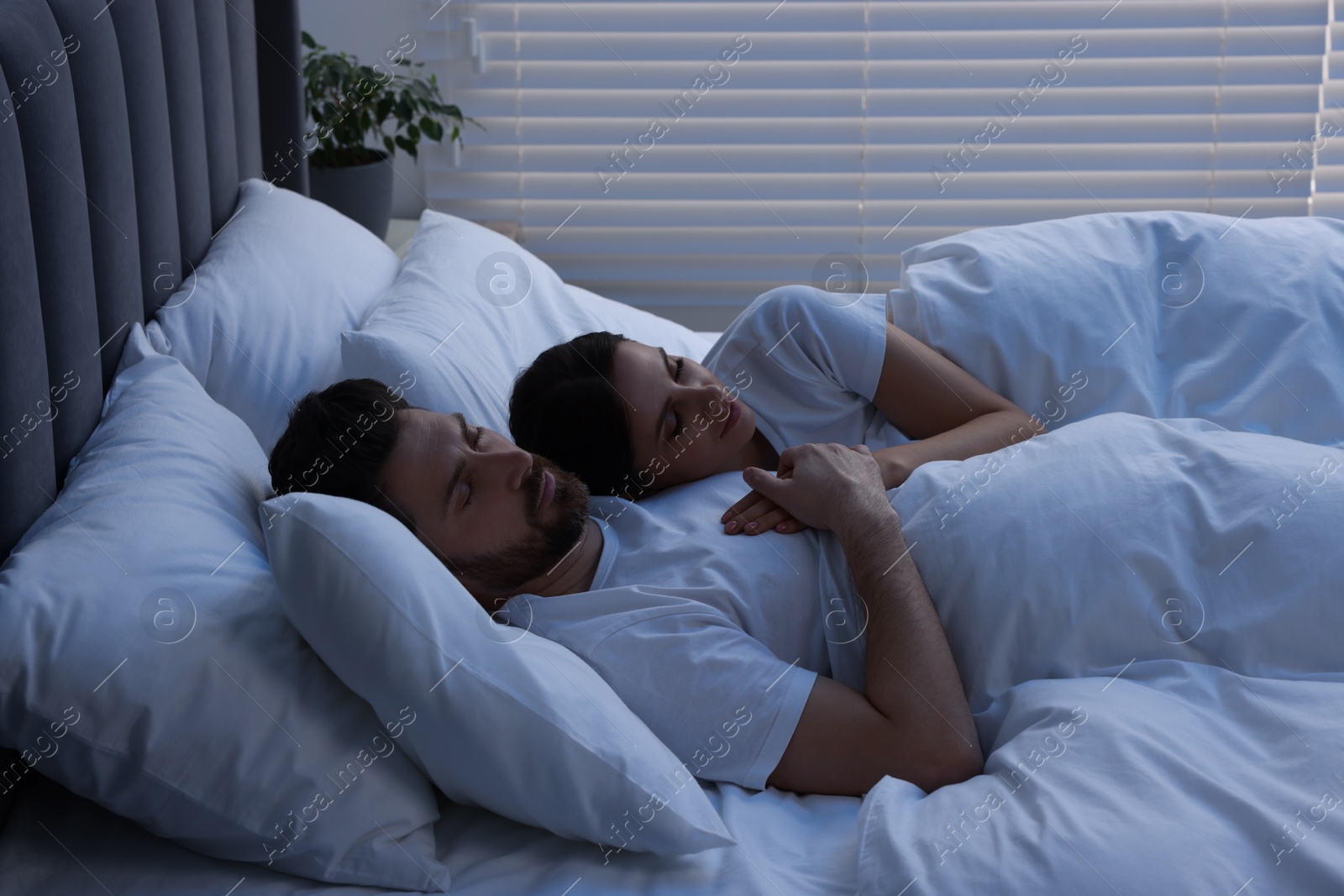 Photo of Lovely couple sleeping together in bed at night